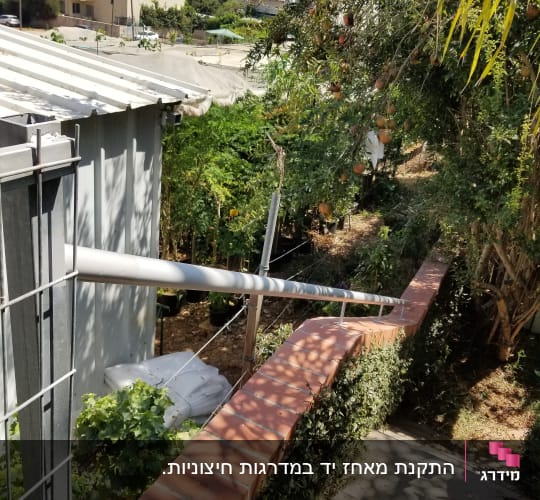 מעקה מתכת עם מסגרת רשת ליד שביל מרוצף